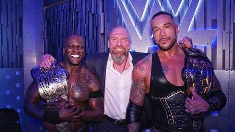 WWE-Vorstand "Triple H" Paul Levesque posiert mit den neuen Champions R-Truth und Damian Priest