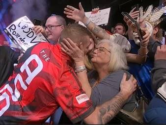 Nathan Aspinall gibt bei seinem Walk-On der Frau von Gegner Andrew Gilding einen Kuss. SPORT1 klärt auf, weshalb Evelyn Gilding so herzlich von Aspinall behandelt wird.