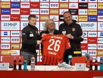 Auf der Pressekonferenz vor dem Spiel gegen Eintracht Frankfurt sorgt Frank Schmidt für einen besonderen Moment. Der Trainer des 1. FC Heidenheim verschenkt ein Trikot an einen Reporter, der seine letzte Pressekonferenz begleitet.