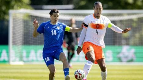 Usbekistans Eldor Shomurodov (l.) und Virgil van Dijk (r.) im Duell