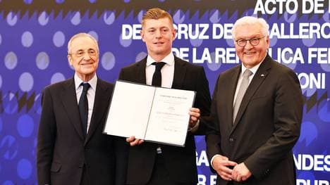 Toni Kroos (M.) erhält von Bundespräsident Frank-Walter Steinmeier (r.) das Bundesverdienstkreuz - im Bernabeu. Auch Real Madrids Präsident Florentino Perez (l.) ist dabei